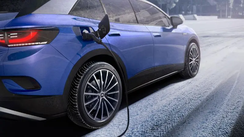 Blaues Fahrzeug parkt auf verschneiter Straße und wird aufgeladen
