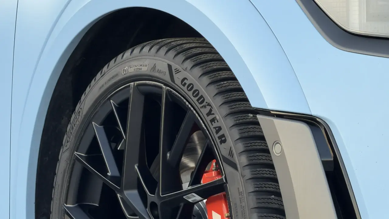Ett Goodyear Vector All Season 4-däck med M+S- och snöflingemärkning monterat på en mattsvart fälg, placerat under den ljusblå stänkskärmen på en Hyundai.