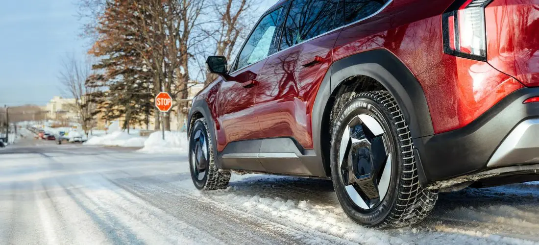 Michelin-däck monterade på en röd SUV på en vinterväg