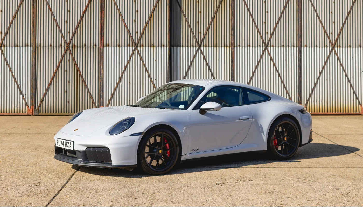 Porsche-Sportwagen vor einem Flugzeughangar
