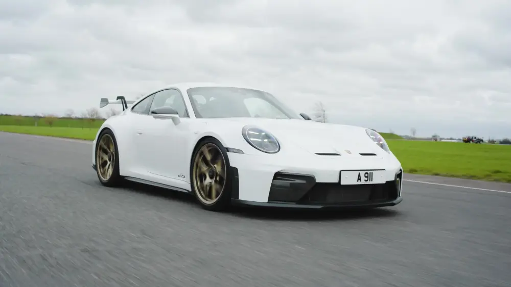 Vit Porsche 911 GT3 (992.2) på racerbanan med synlig bakvinge