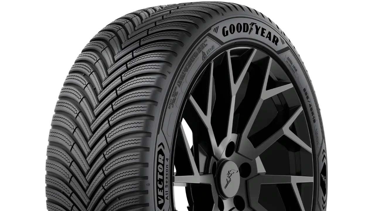 O fotografie realizată în studio a unei anvelope Goodyear Vector All Season 4 pe fundal alb, care prezintă banda de rulare în formă de V cu lamele ondulate și o jantă închisă la culoare cu mai multe spițe în spate.