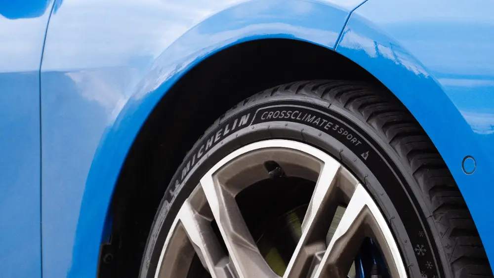 Michelin CrossClimate-däck monterat på en blå bils hjul, med synligt mönster mot karossen.