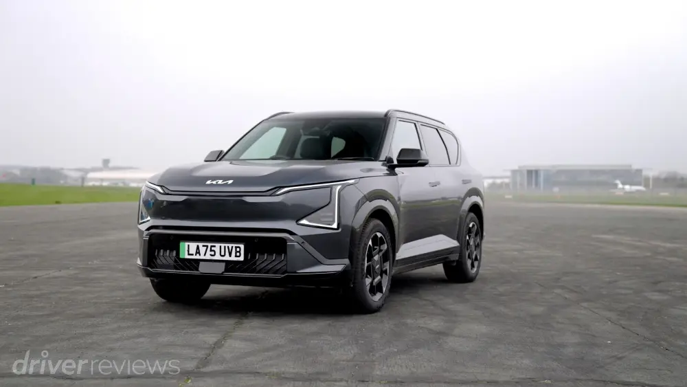 Kia EV9 in Graphitgrau, Frontansicht von der Seite fotografiert, geparkt auf einem Flugplatz.