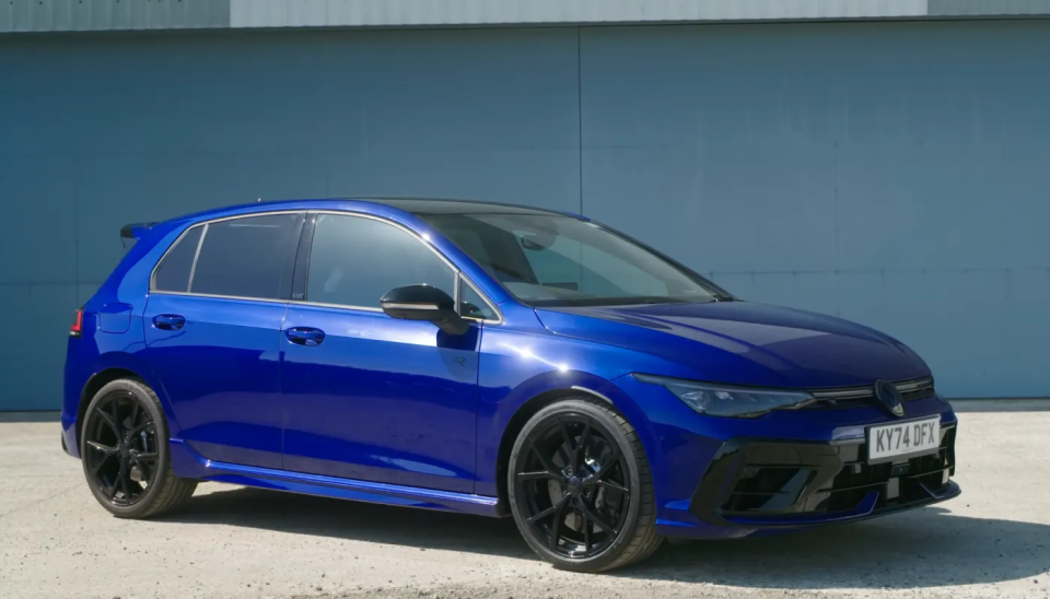 En Volkswagen Golf R MK8.5 parkerad framför en flygplanshangar