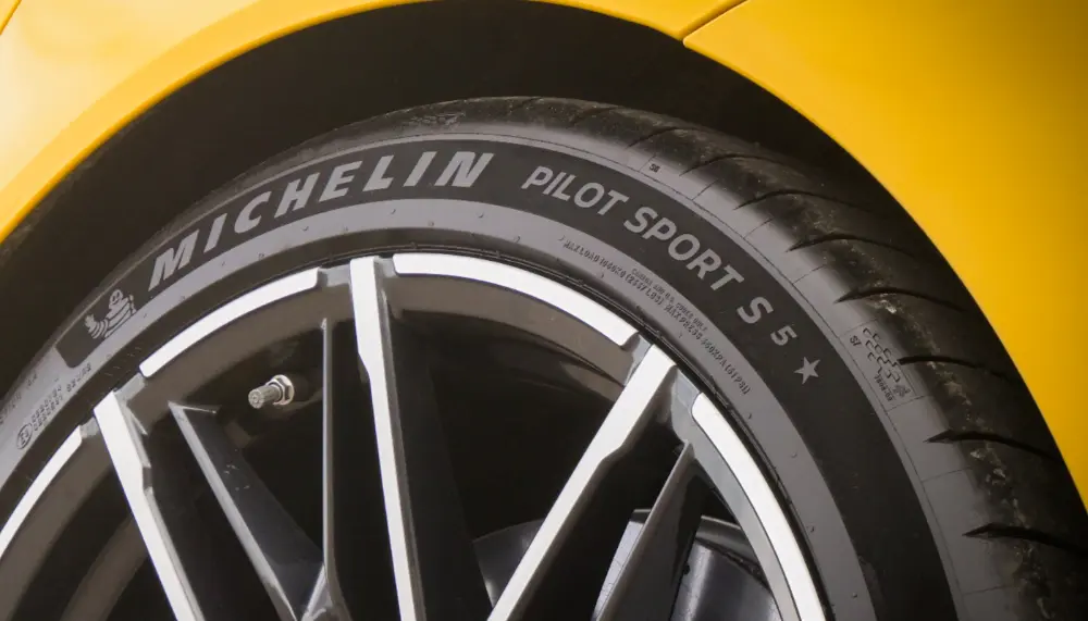 Primo piano di uno pneumatico Michelin Pilot Sport 5 montato su un’auto gialla